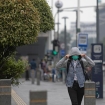 Warga melintas di bawah terik matahari saat suhu di Jabodetabek mencapai puncaknya hingga 36 derajat Celcius. (Foto: RSS)