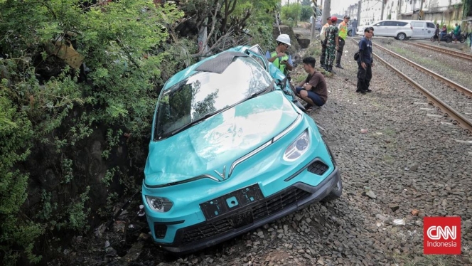 
 Petugas kepolisian saat melakukan olah TKP dan investigasi pada unit taksi listrik Green SM yang mengalami kecelakaan di perlintasan sebidang. (Foto: RSS)