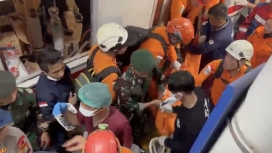 Petugas mengevakuasi satu kantong jenazah dari gerbong KRL yang ringsek usai tertabrak KA Jarak Jauh di Stasiun Bekasi Timur. (Foto: RSS)