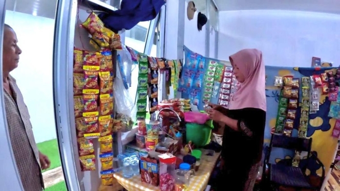 
 Seorang penyintas bencana di Aceh (Reni) sedang menyiapkan dagangan jajanan di warung kecil miliknya yang berlokasi di area Hunian Sementara (Huntara). (Foto: RSS)