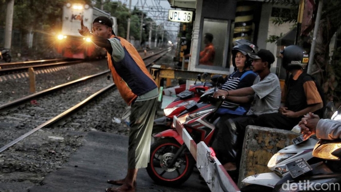 
 Petugas penjaga perlintasan kereta api saat bertugas memastikan keamanan perjalanan kereta di perlintasan sebidang. (Foto: RSS)