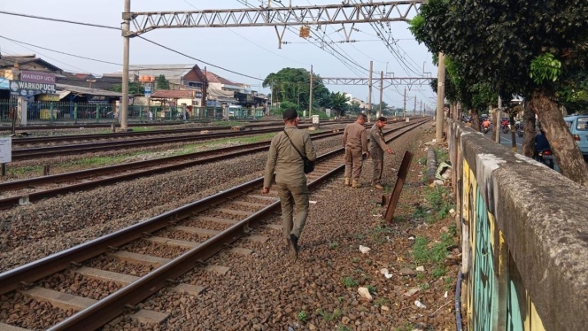 
 Petugas Satpol PP saat meninjau dan menutup akses masuk ilegal di kawasan rel kereta api Jatinegara, Jakarta Timur. (Foto: RSS)