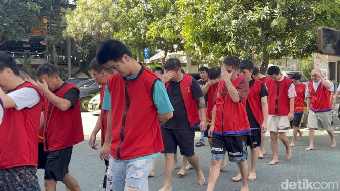 
 Aparat kepolisian saat melakukan penggerebekan di markas komplotan scamming internasional yang melibatkan 44 WNA di Surabaya. (Foto: RSS)